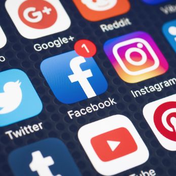 social media icons on a phone focusing on facebook