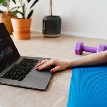 hand on laptop setting up fitness music equipment