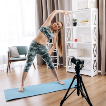 woman teaching fitness at home online in front of a camera